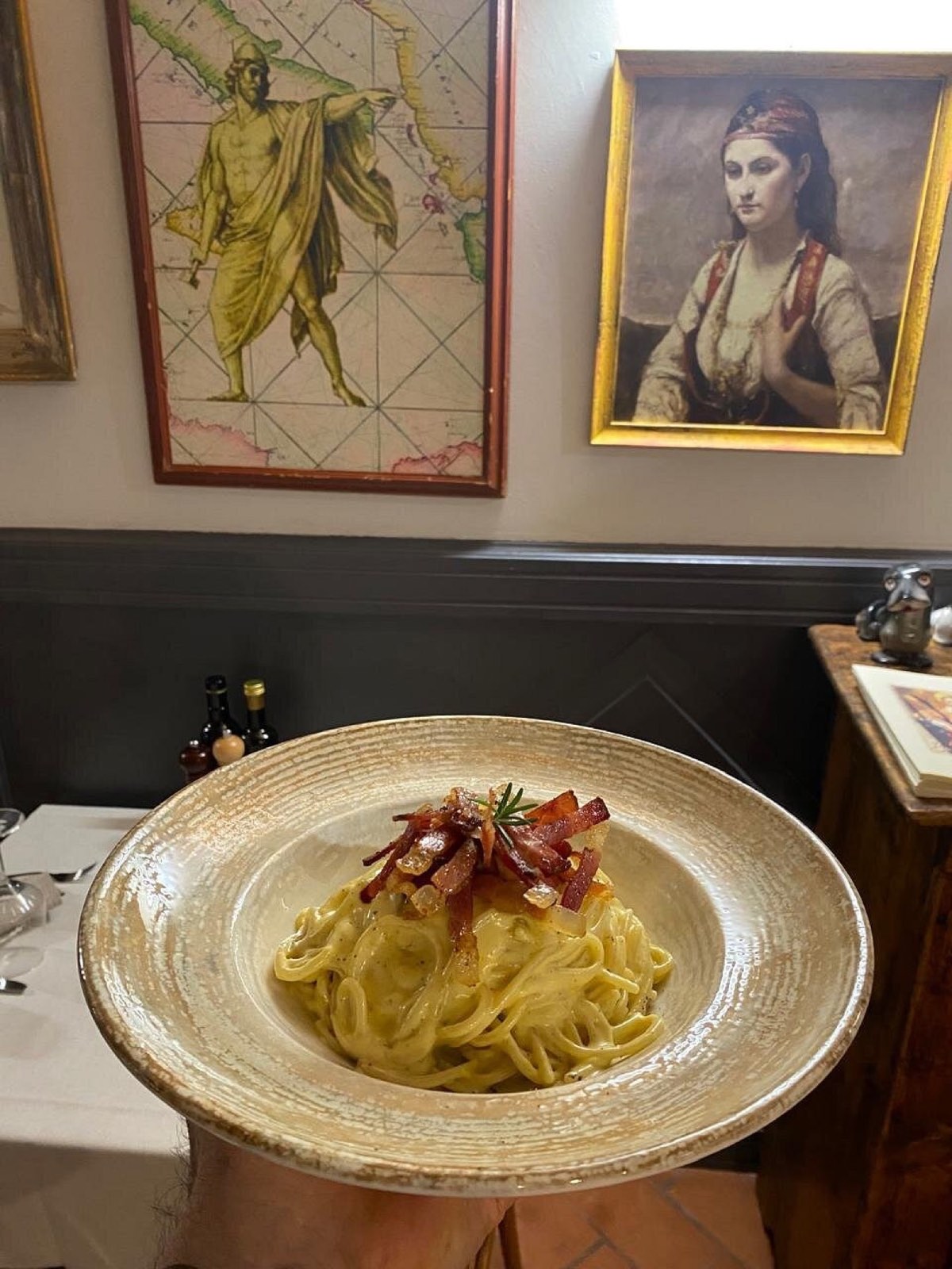 Spaghetti alla carbonara con guanciale croccante, serviti in sala
