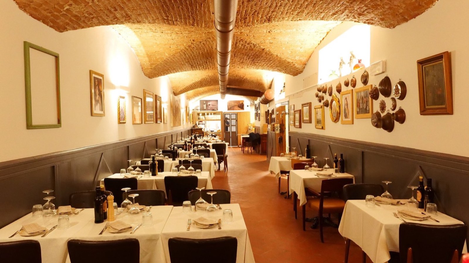 La sala storica della Buca San Lorenzo: volte in mattoni del 1309, tavoli apparecchiati con tovaglie di lino
